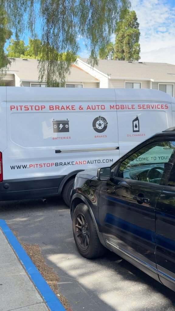 PitStop Brake and Auto mobile services van signwritten with batteries, brakes and oil changes, parked beside a customer vehicle